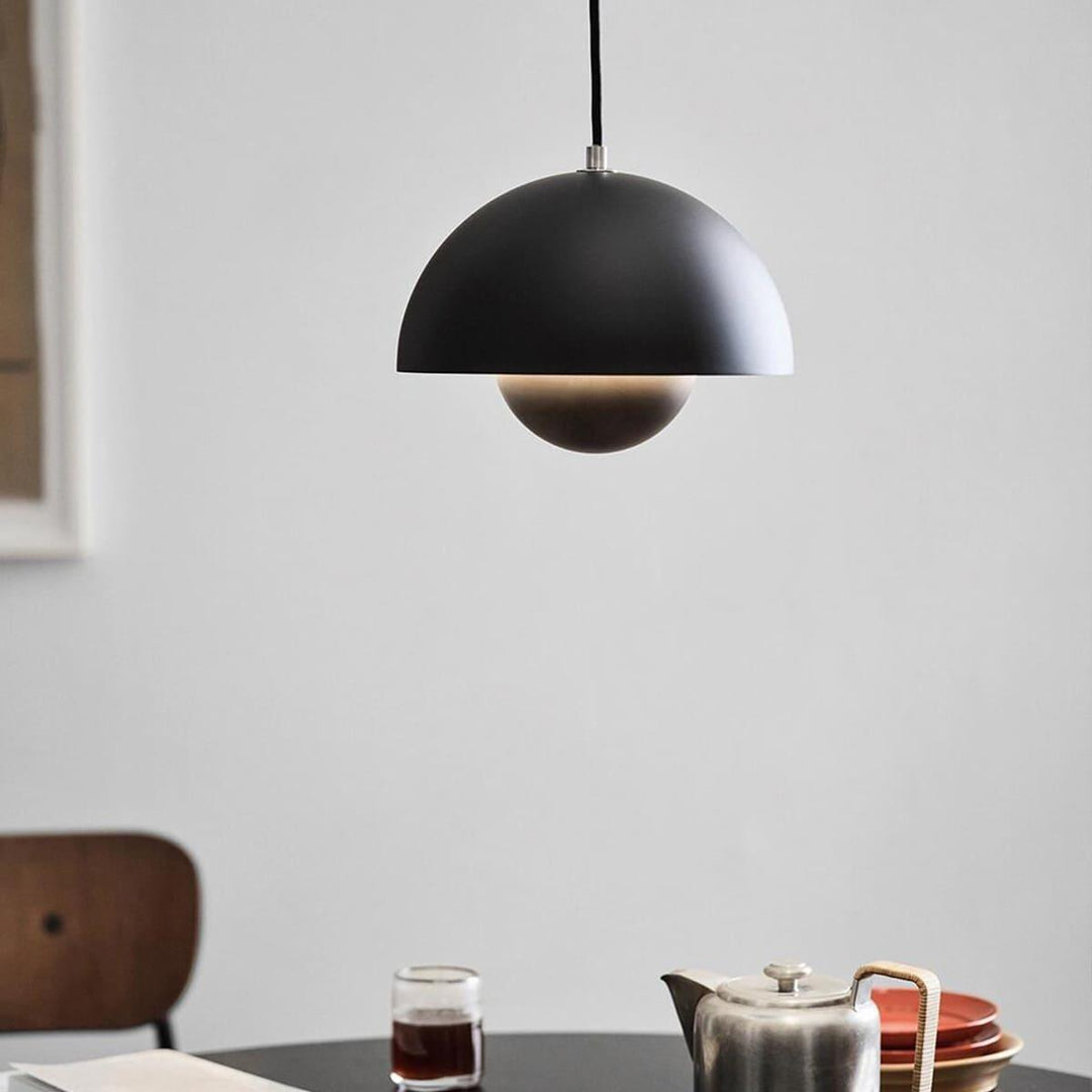 Matte black Flowerpot pendant lamp shown above a table setting.