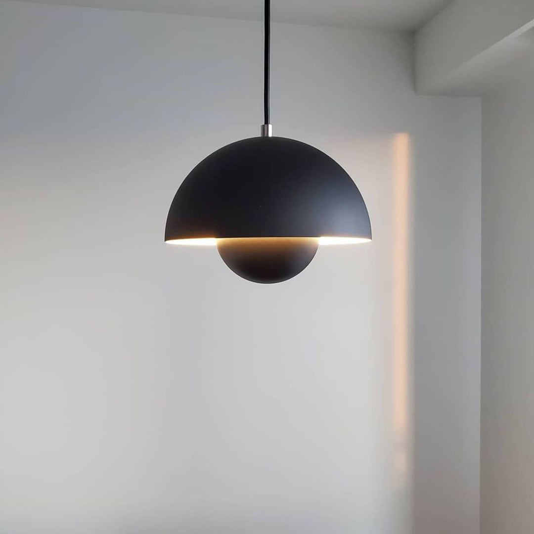 Matte black Flowerpot pendant lamp shown against a wall.