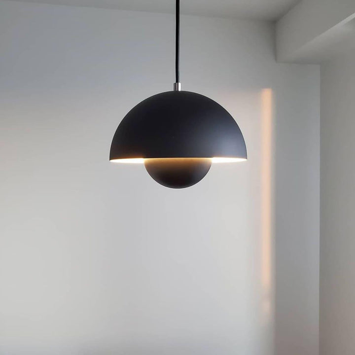 Matte black Flowerpot pendant lamp shown against a wall.