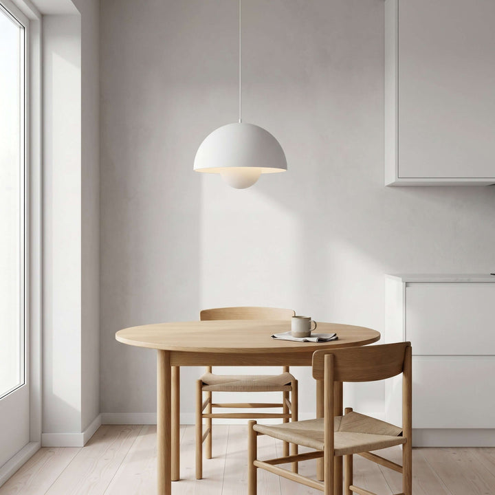 Matte white Flowerpot pendant lamp shown above a small breakfast table.