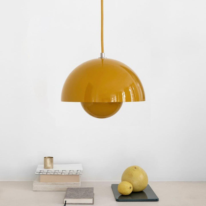 Yellow Flowerpot pendant lamp shown above a small shelf.