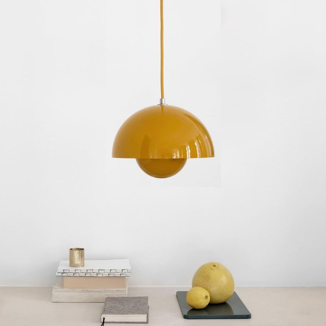 Yellow Flowerpot pendant lamp shown above a shelf with decor.