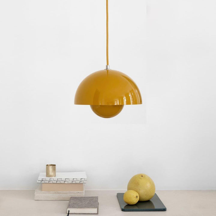 Yellow Flowerpot pendant lamp shown above a shelf with decor.