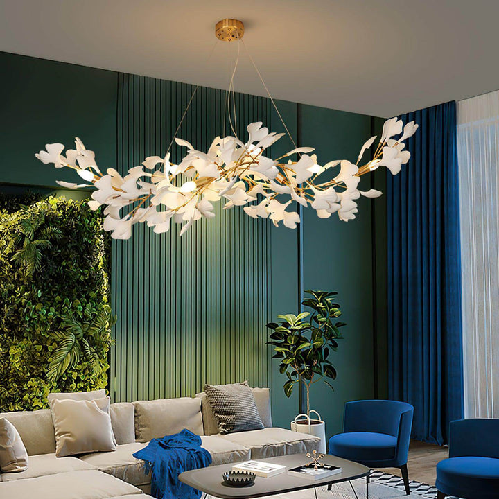 Ceramic leaf chandelier above a living room with blue seating and green wall panels.