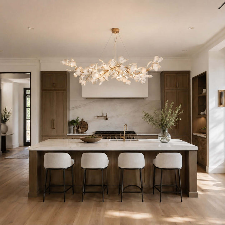 Gingko chandelier hanging over a bright kitchen island with white stools.