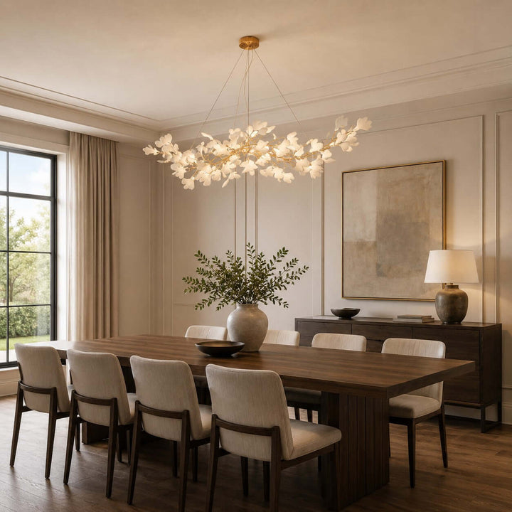 Gingko ceramic leaf chandelier centered over a dining table in a warm dining room.