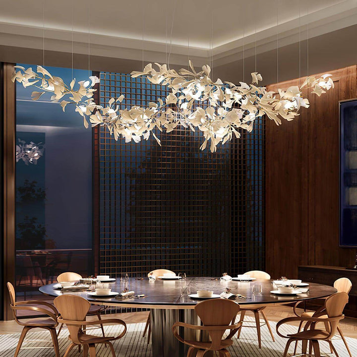 Long ceramic leaf chandelier above a dining table in a restaurant-style interior.