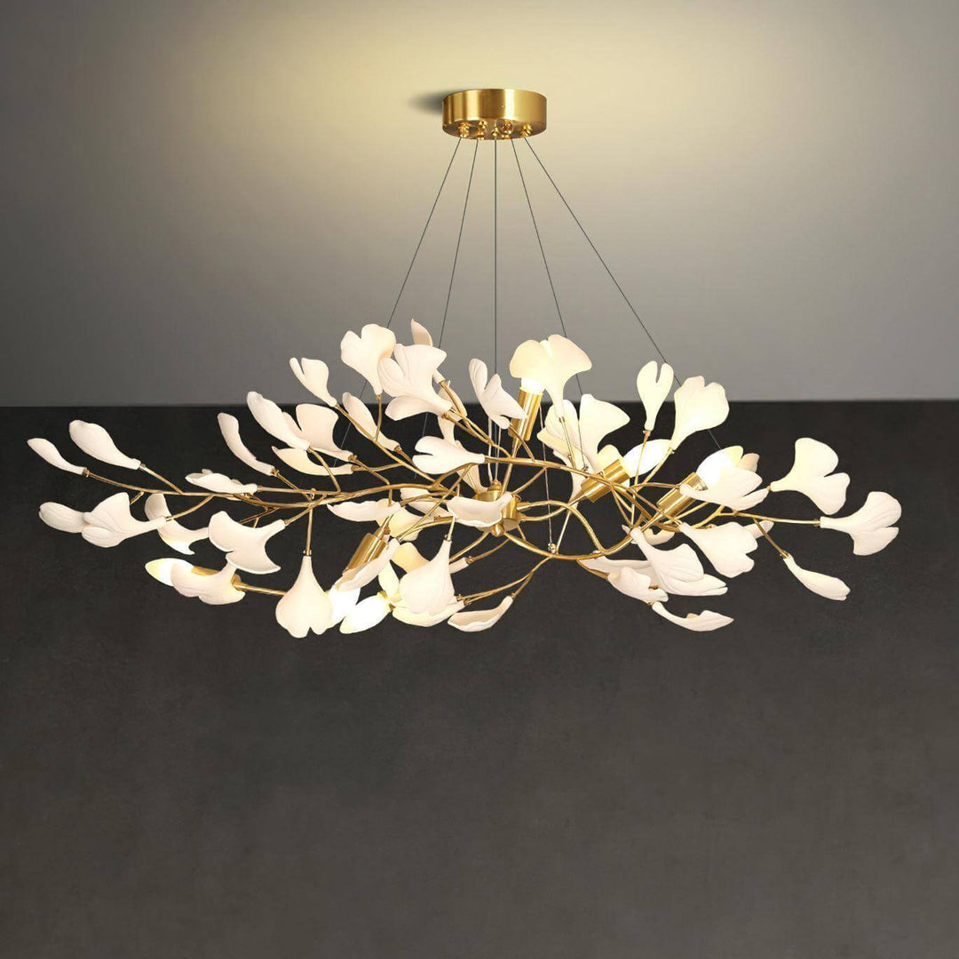 Suspended Gingko ceramic leaf chandelier shown lit against a dark gray background.