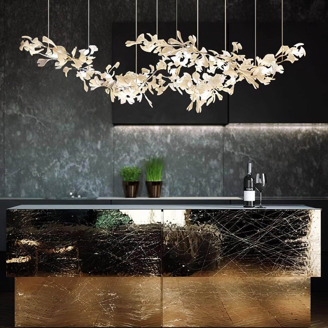 Gingko ceramic leaf chandelier glowing above a dark marble bar.
