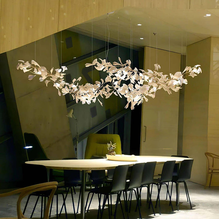 Gingko linear chandelier above a table in a glass wall meeting room.