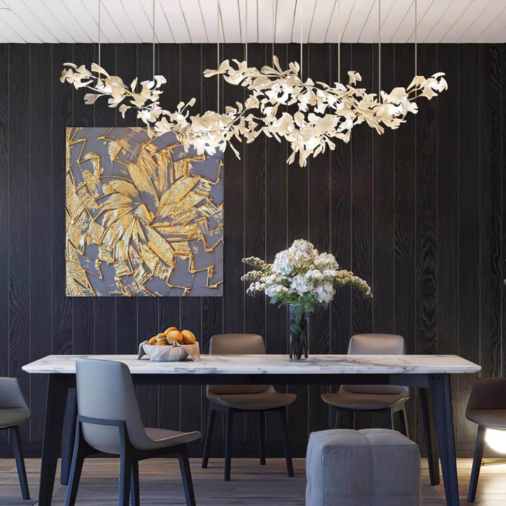 Gingko linear chandelier above a dining table with modern wall art.
