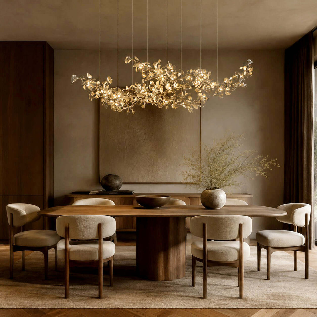 Ceramic leaf linear chandelier glowing above a warm dining room table.