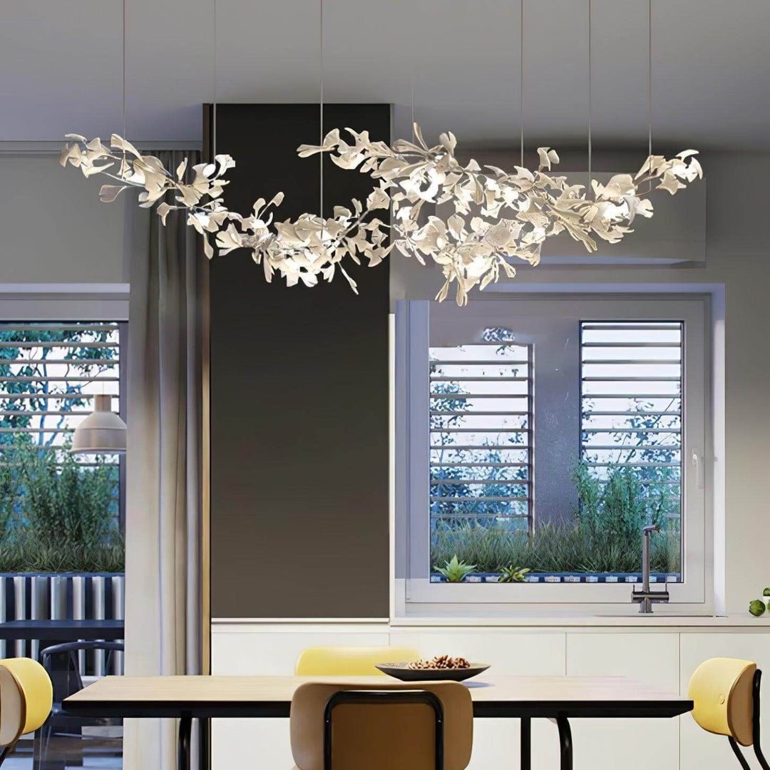 Linear ceramic leaf chandelier hanging above a table near tall windows.