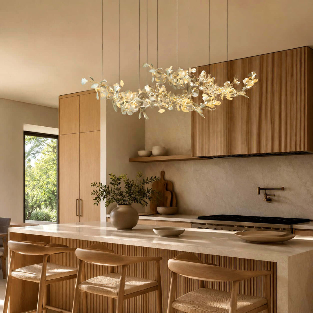 Linear ceramic leaf chandelier glowing above a wood kitchen island.