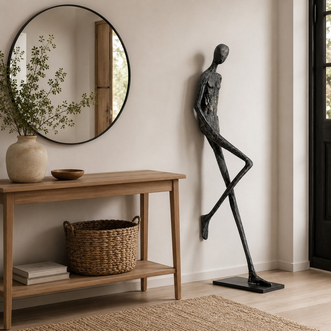 Black Lemvix sculpture beside a wood console table in a bright entryway.