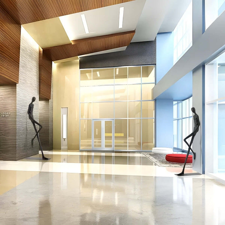 Two black resin sculptures displayed across a bright modern lobby.