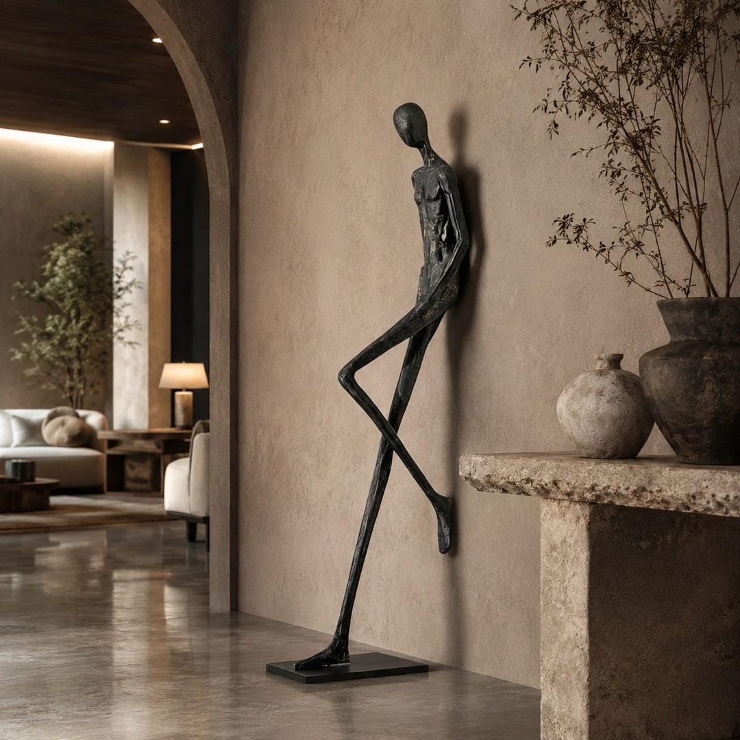 Black abstract sculpture standing beside a rustic console in a hallway.