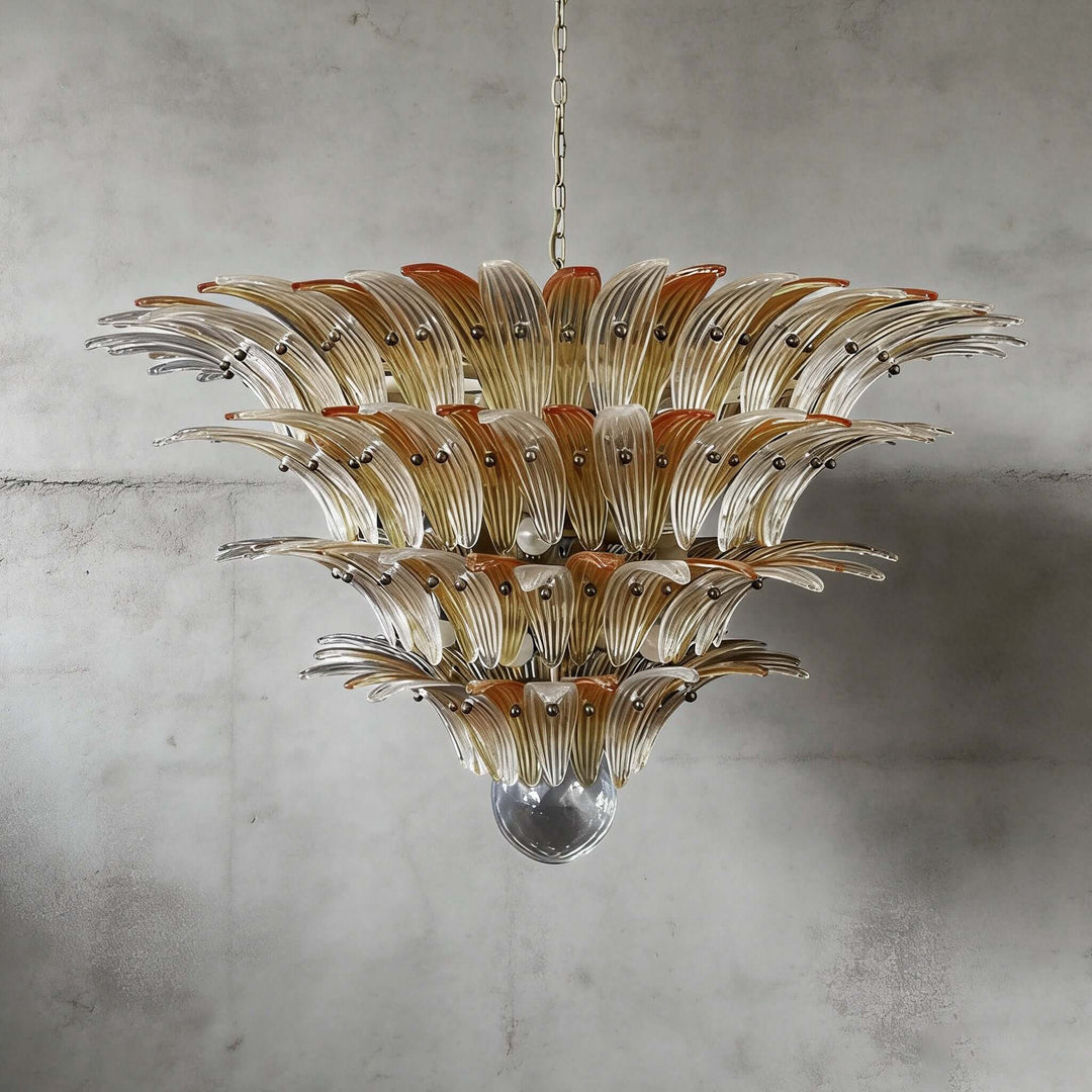 Amber glass Palmette chandelier shown in a large tiered studio view on a gray wall.
