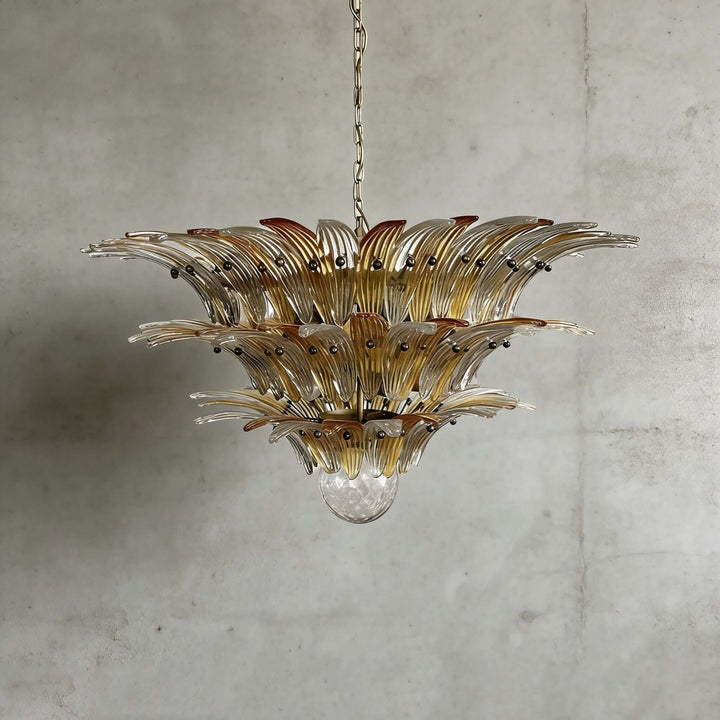 Amber glass Palmette chandelier shown in a wider studio view on a gray wall.