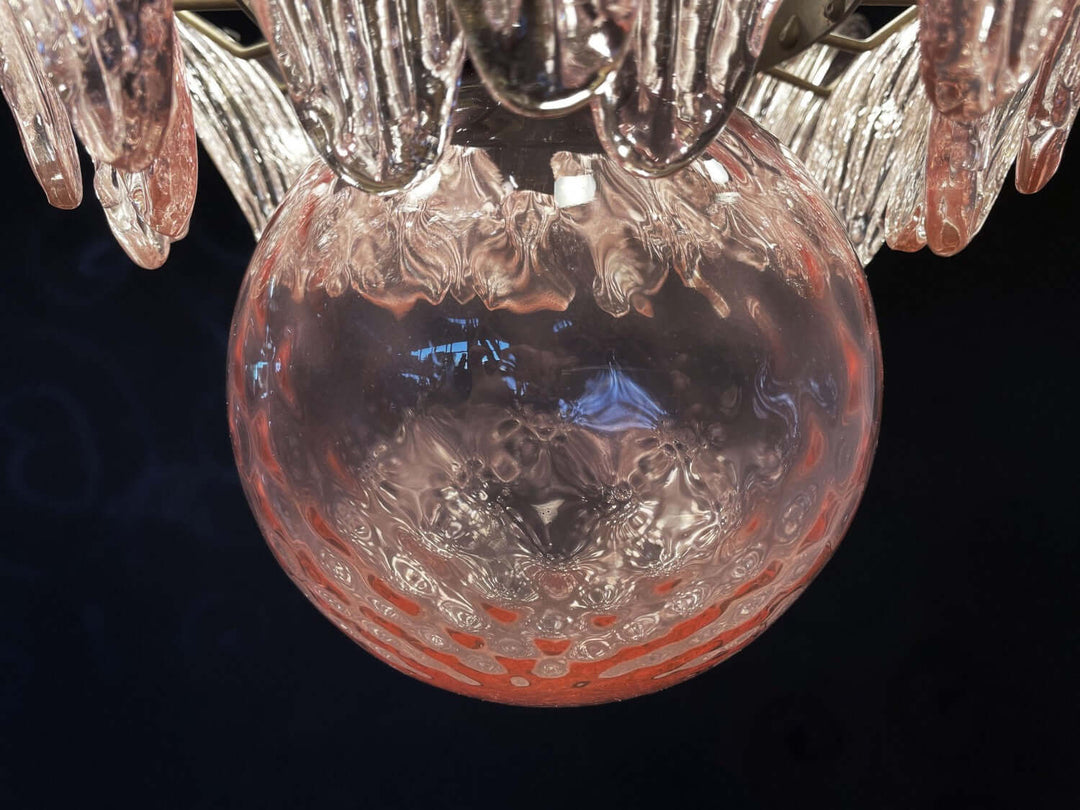 Close-up of the pink glass globe and clear leaf shades on the chandelier.