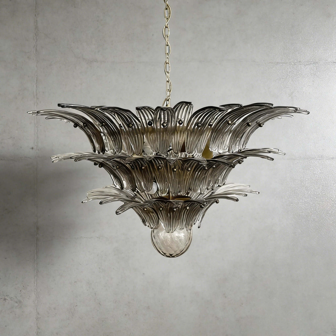 Smoky gray glass Palmette chandelier shown in a wider studio view on a gray wall.