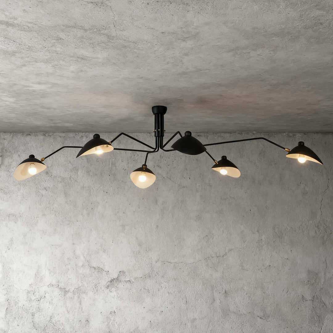 Black six-light ceiling fixture with angled arms on a concrete wall background.