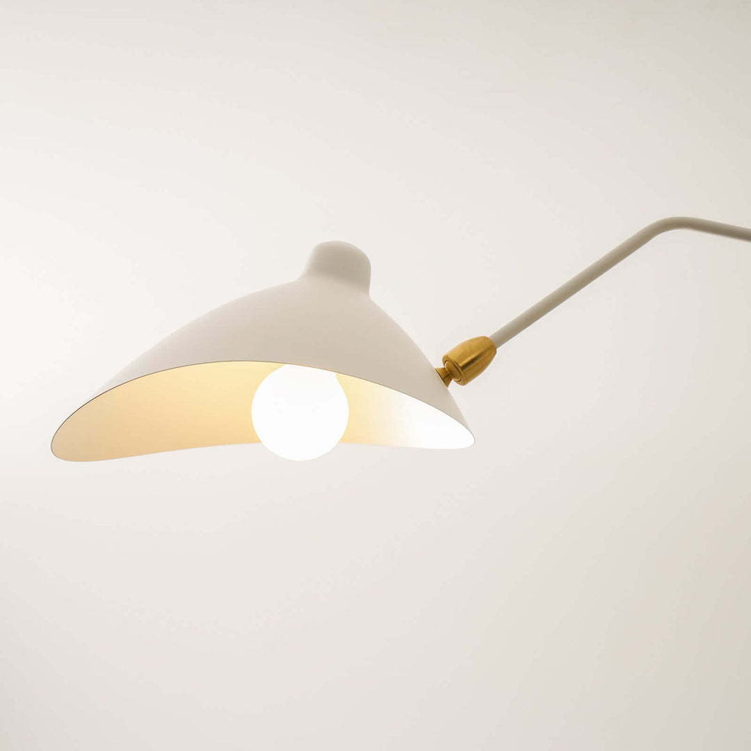 Close-up of a white cone shade and glowing bulb on the ceiling light.