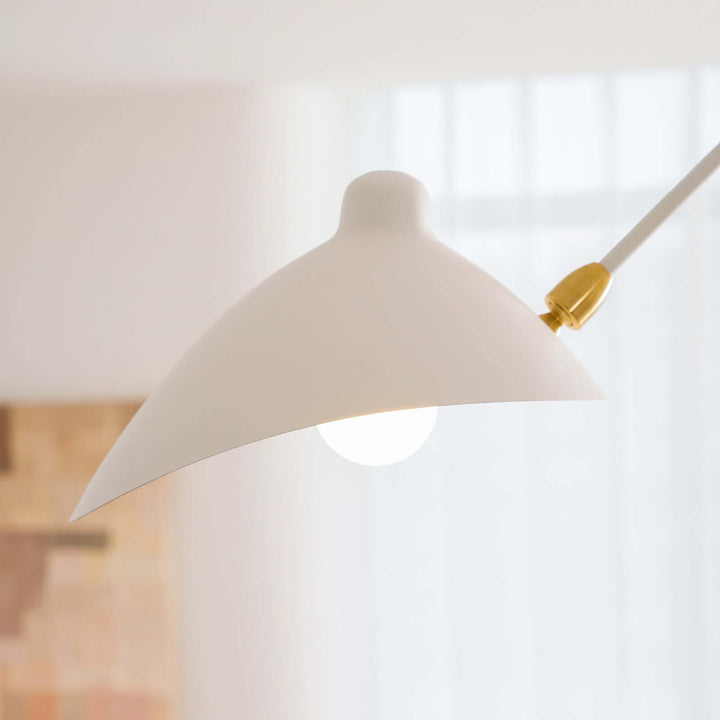 Side close-up of a white cone shade with a small brass connector.
