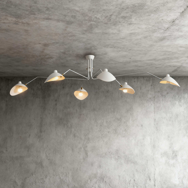 White six-light ceiling fixture with angled arms on a concrete wall background.