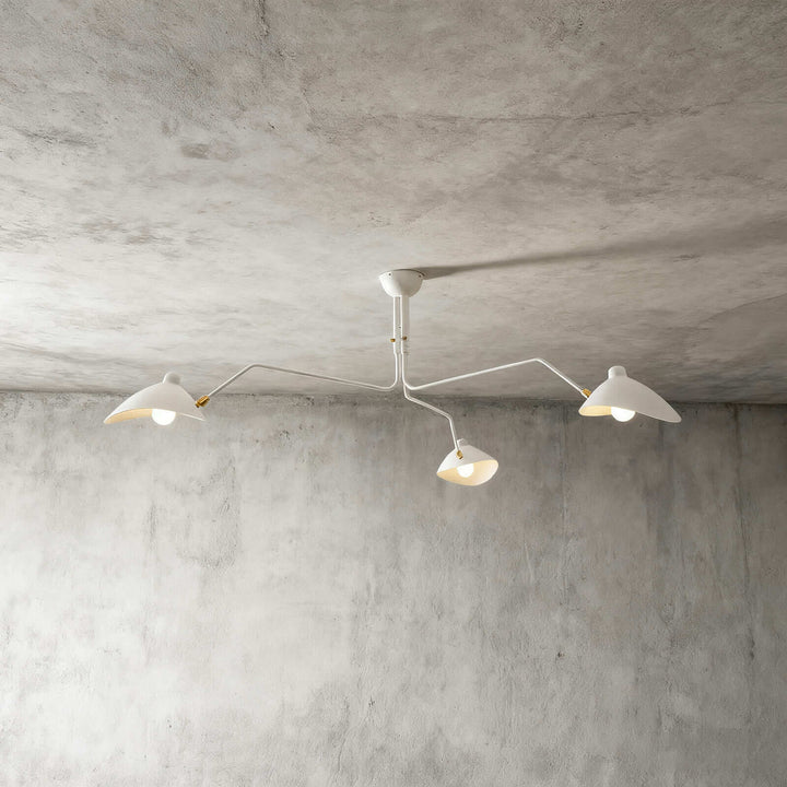 White three-light ceiling fixture shown against a concrete wall background.