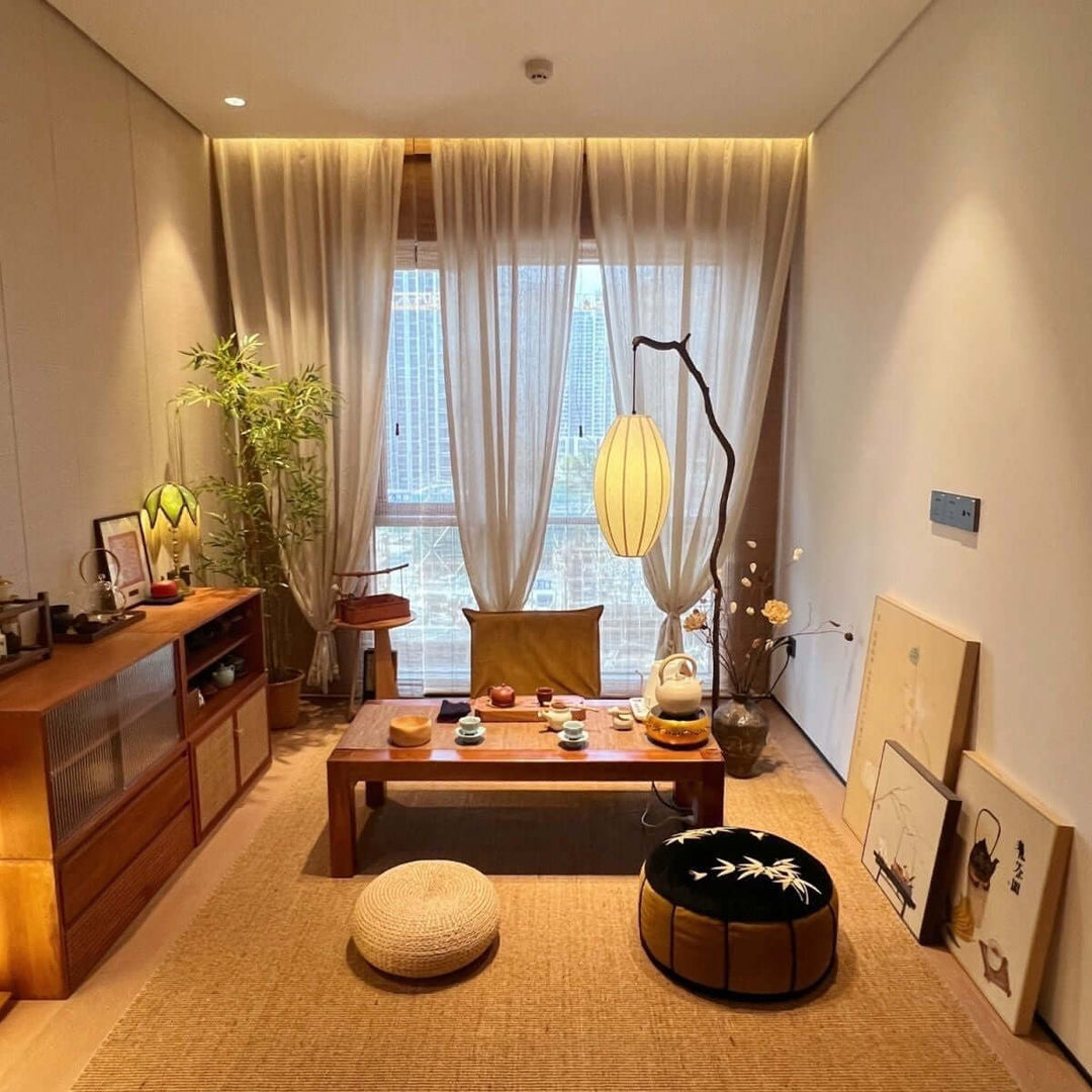 Sivon Tree floor lamp glowing beside a low table in a warm living room.