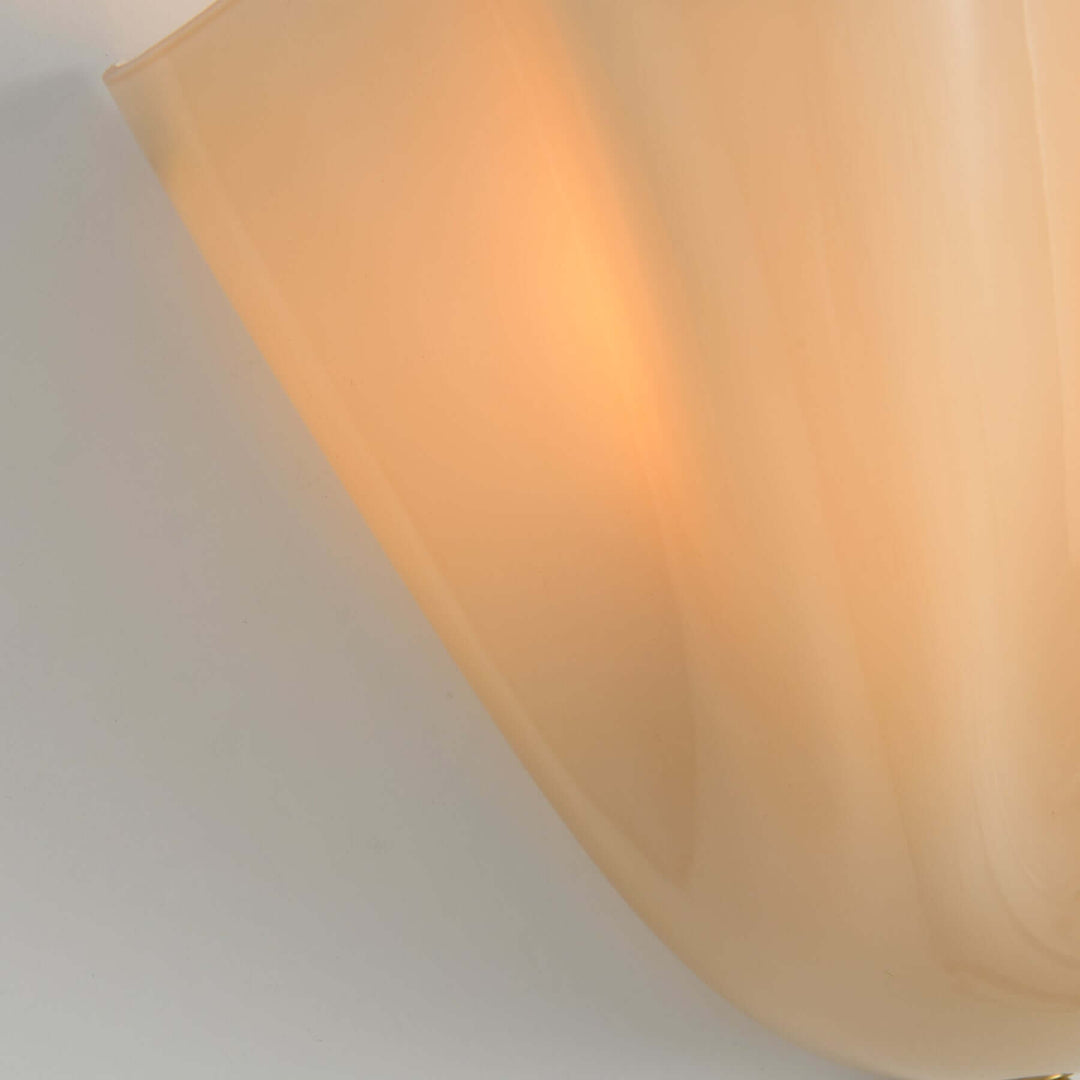 Close-up of the beige fluted glass shade glowing with warm light.