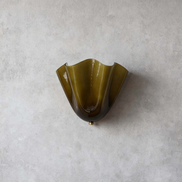 Green fluted glass wall sconce shown from a front angle on a gray wall.