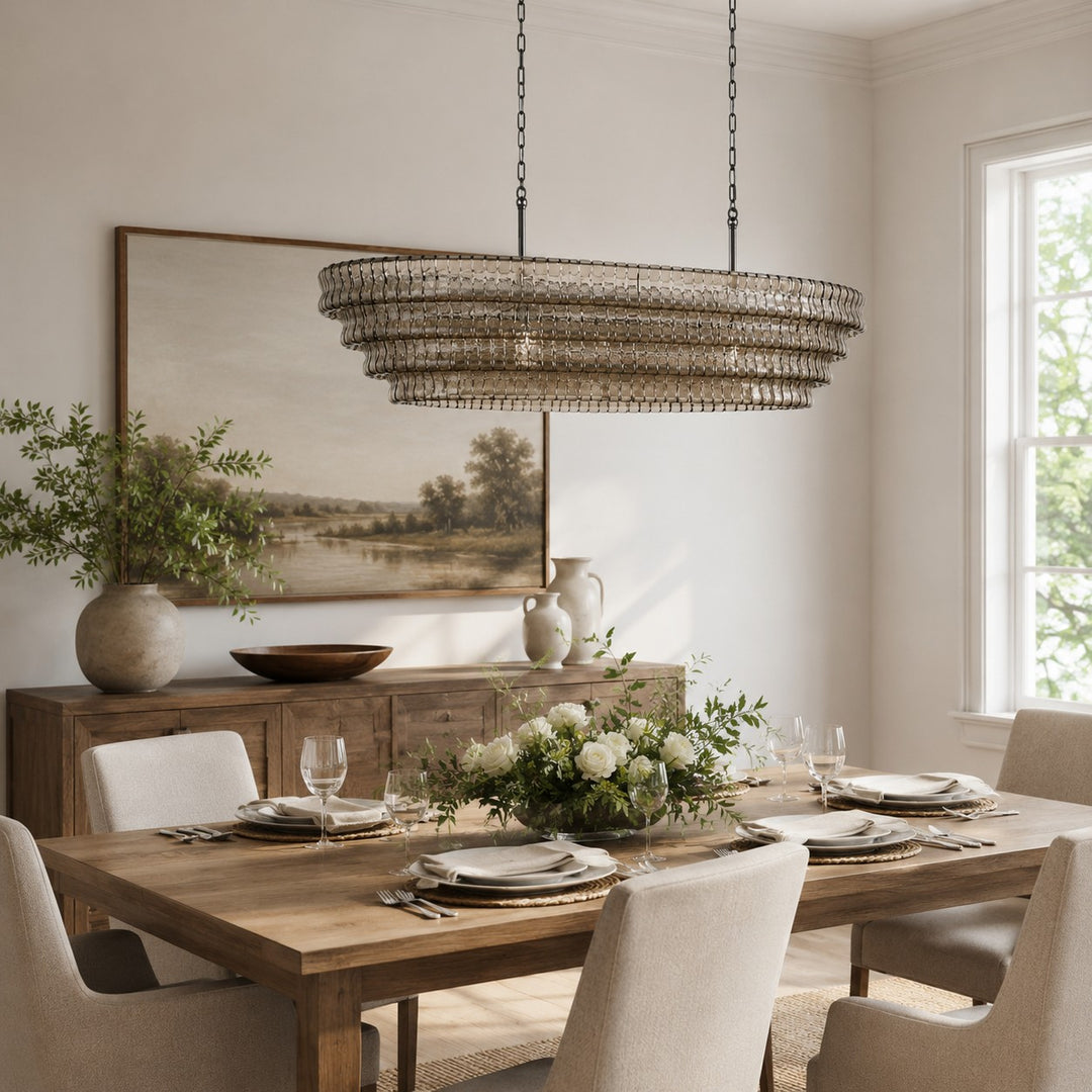 Wide round glass chandelier above a rectangular dining table in a bright room.