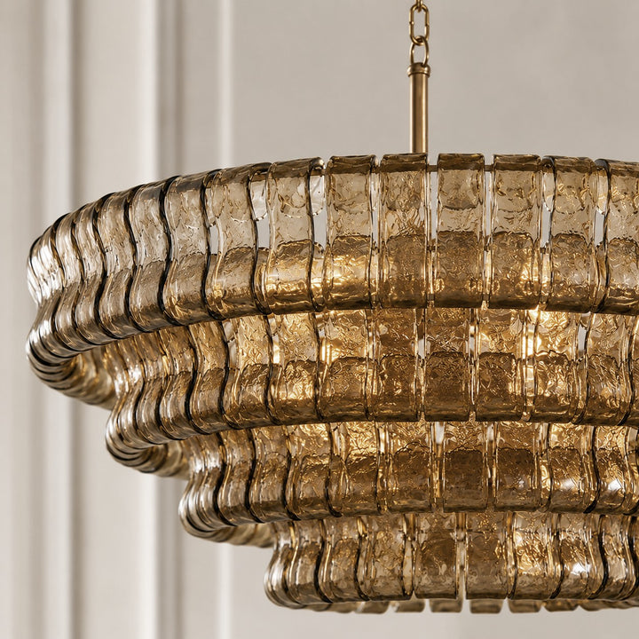 Close-up of smoky wavy glass panels and warm light on the Zirvona chandelier.