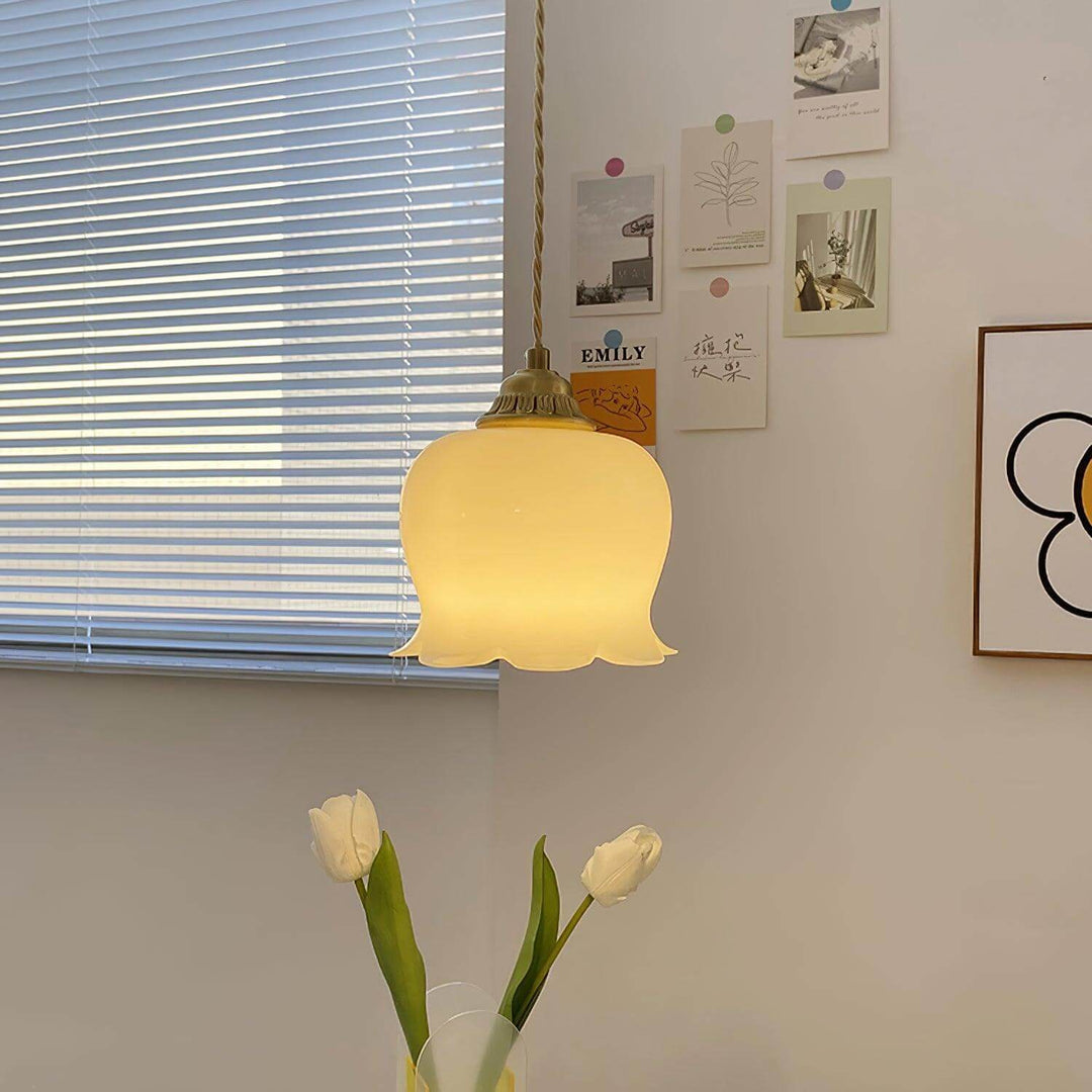 Vintage flower pendant light glowing near a window and floral wall art in a cozy interior
