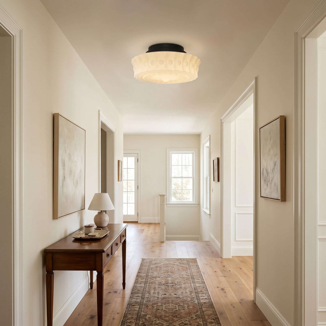 Vintage round milk glass flush mount ceiling light illuminating a bright hallway