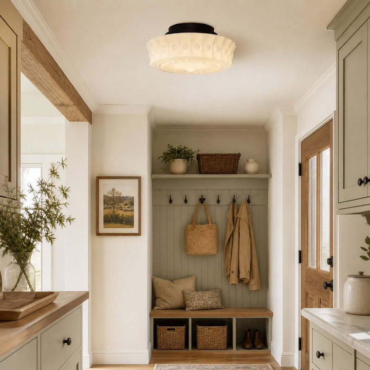 Vintage creamy milk glass semi-flush mount ceiling light above an entryway storage bench