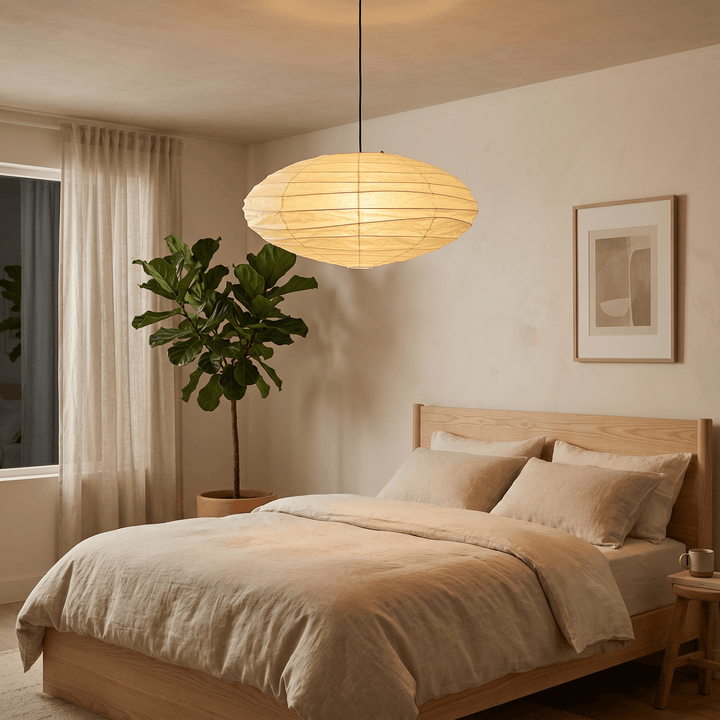 Washi paper pendant light glowing above a neutral bedroom.