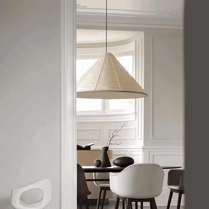 Large Washi paper pendant lamp above a dining table in a bright room with traditional wall molding