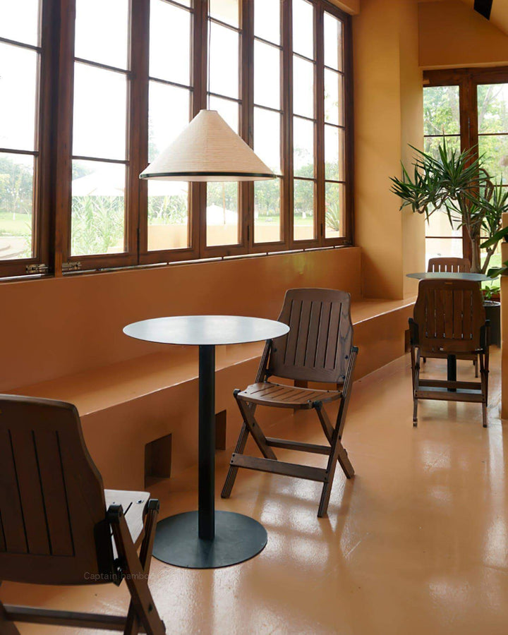 Washi paper pendant lamp above a small round table in a warm modern café seating area