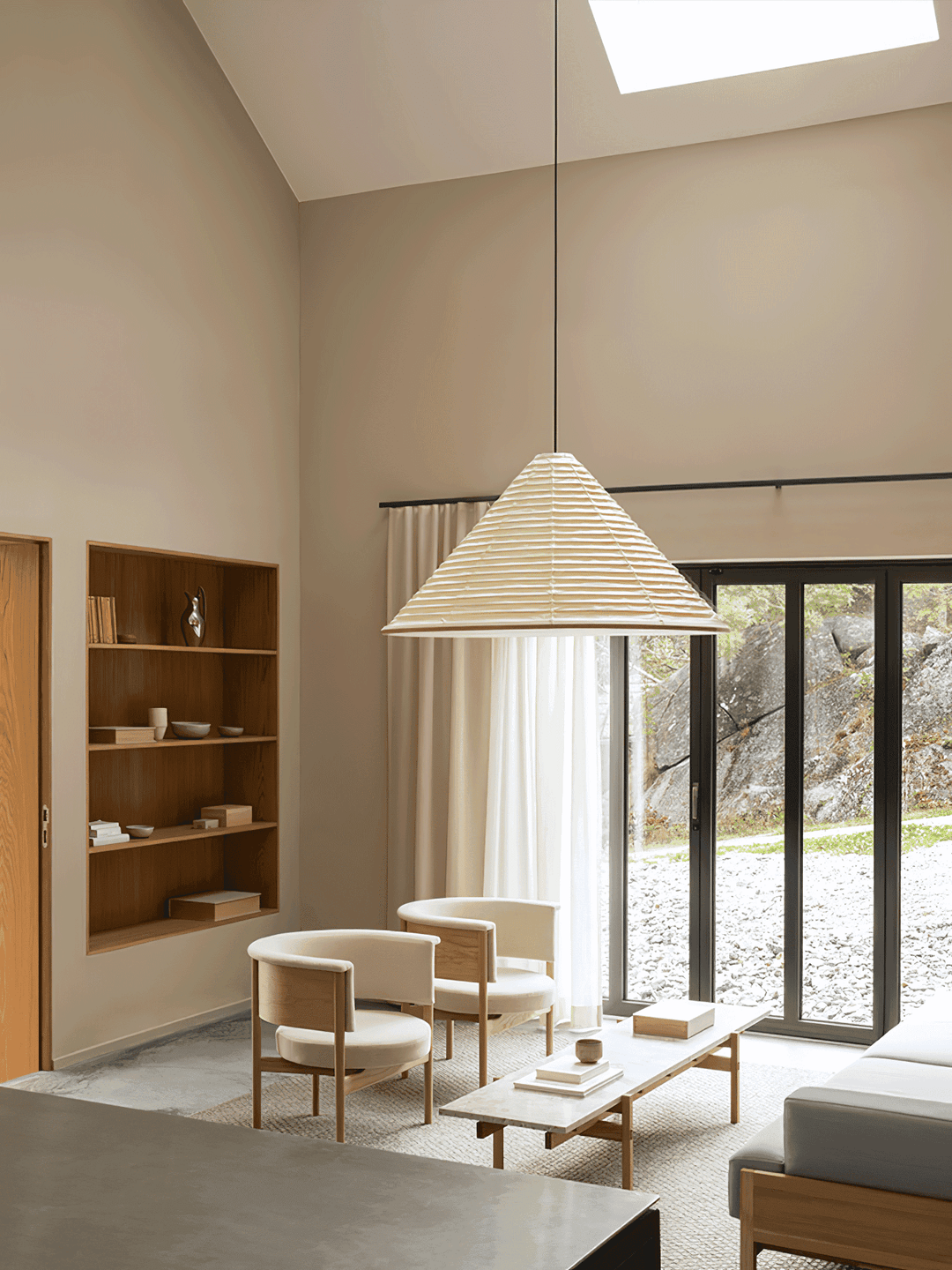Large Washi paper pendant light hanging from a high ceiling above a bright living room seating area