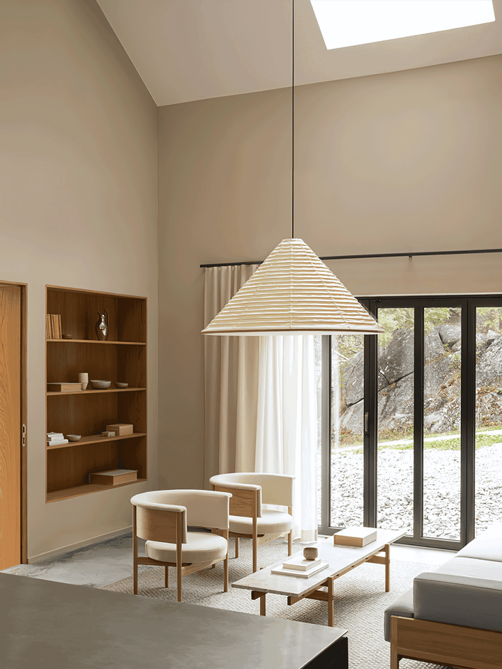 Large Washi paper pendant light hanging from a high ceiling above a bright living room seating area