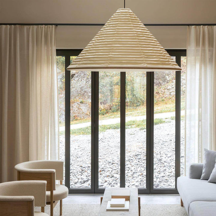 Large ribbed Washi paper pendant shade in a minimalist living room with floor-to-ceiling glass doors