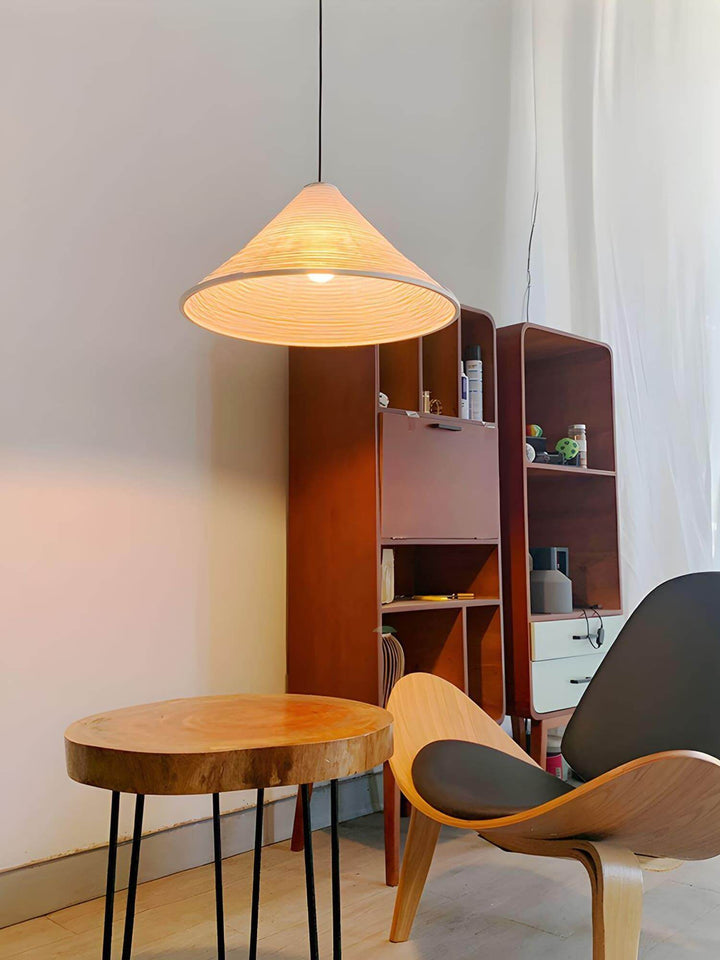 Illuminated Washi paper pendant light above a small round table and modern chair in a cozy reading nook