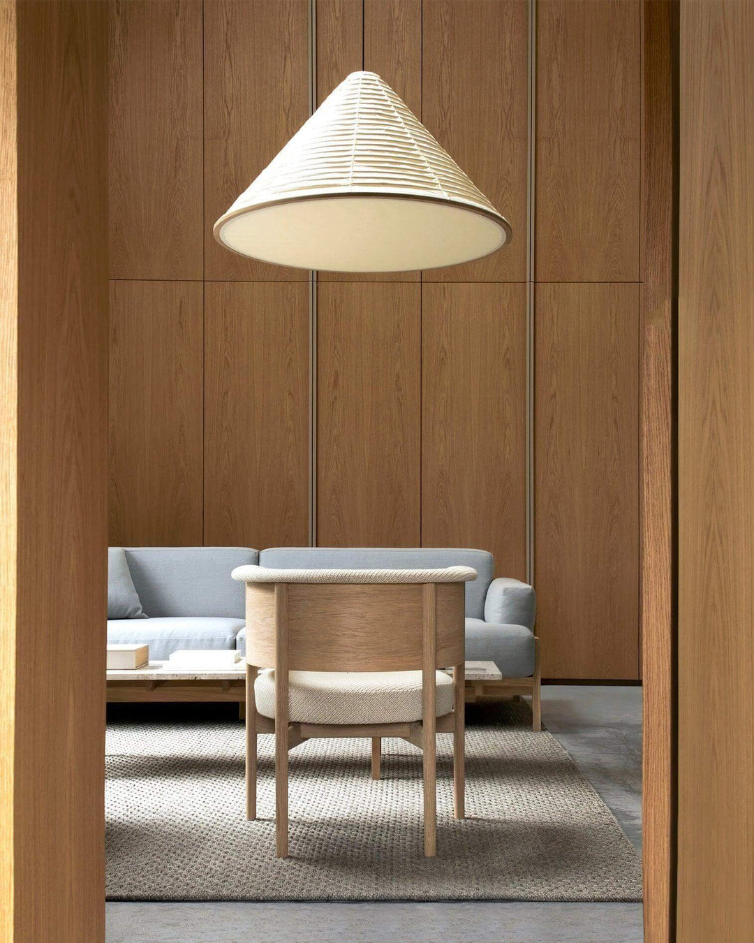 Washi paper pendant lamp with a bottom diffuser in a wood-paneled contemporary lounge