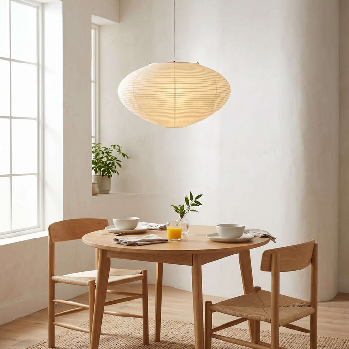 Oval washi paper pendant light over a small wood dining table.