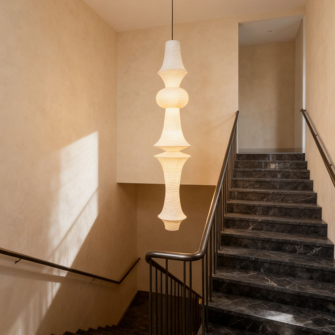 Washi paper pendant light displayed between clothing rails in a minimalist fashion boutique