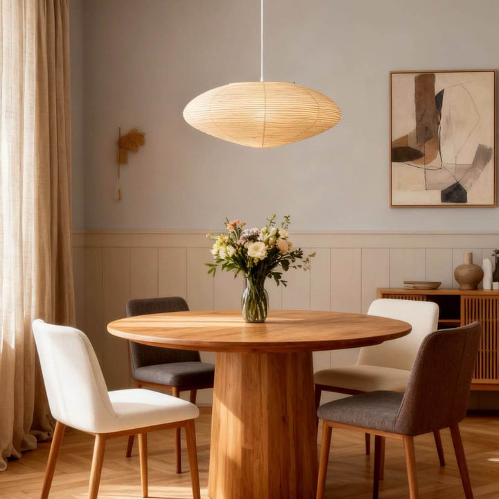Washi paper pendant light over a round wood dining table.