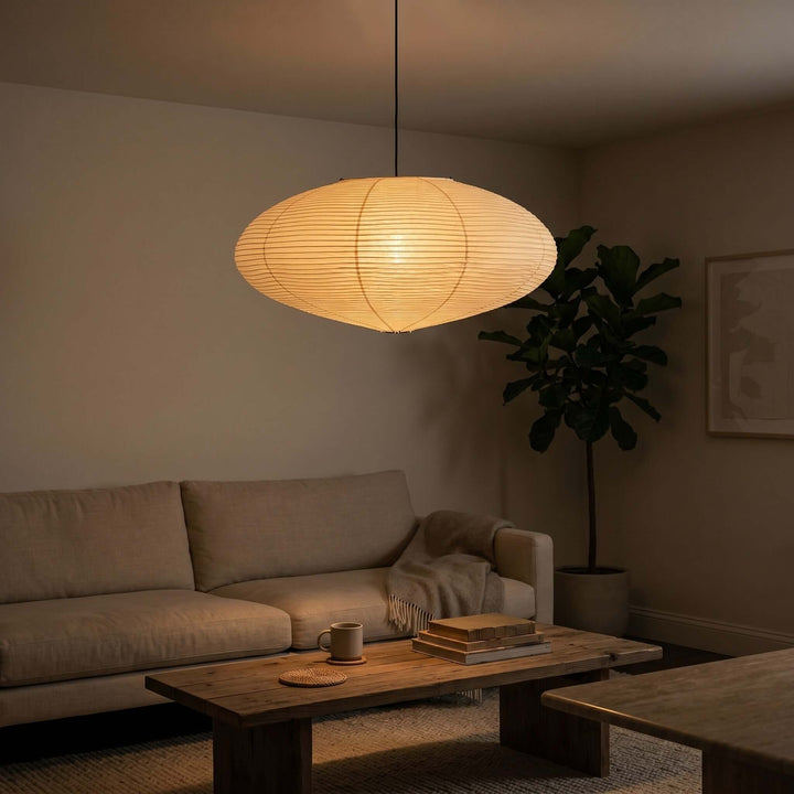 Warm glowing washi paper pendant light above a living room coffee table.